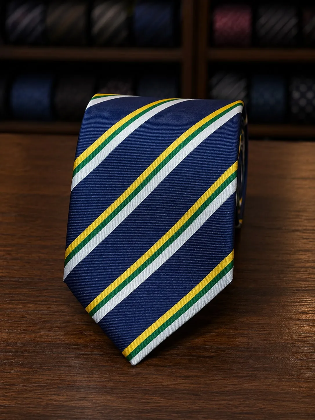 Gravata clássica azul-marinho com listras diagonais amarelas, verdes e brancas