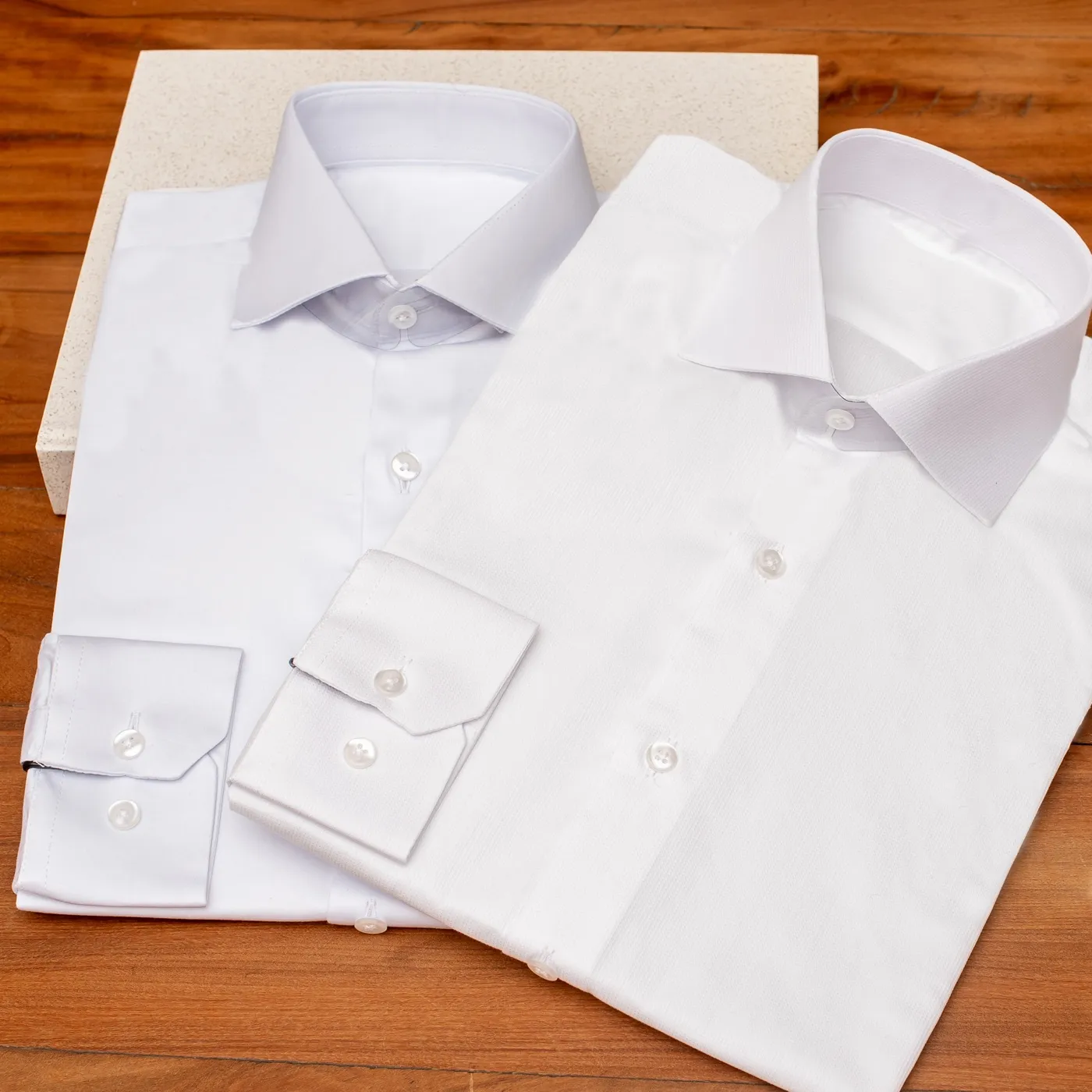 Camisas sociais brancas dobradas, prontas para receber etiqueta